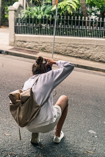 Person Kneeling on Road While Taking Picture