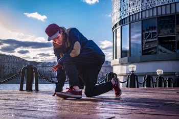 Person Kneeling With One Leg on Footbridge