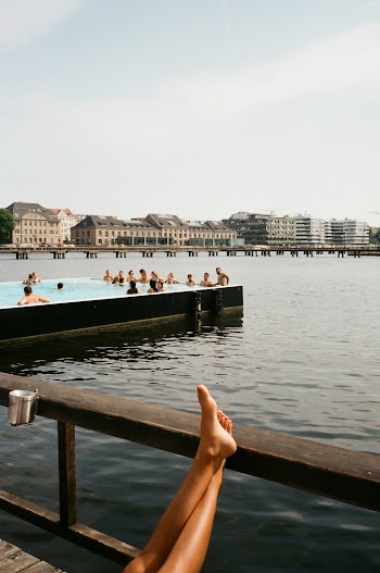 Person Leaning Feet on Wooden Railing