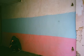 Person Leaning on Blue, White, and Pink Wall
