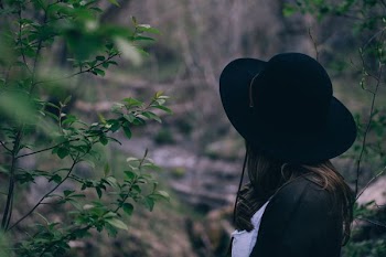 person looking to a pile of branches