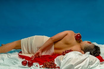 Person Lying On Bed With Apples And Grapes