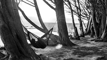 Person Lying on Hammock in Greyscale Photography