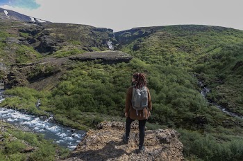 Person Near Cliff Above Stream