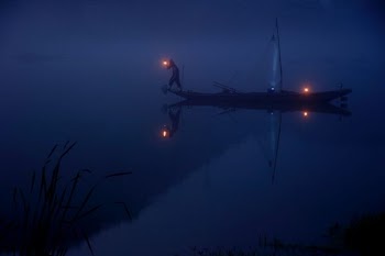 person on boat holding lantern