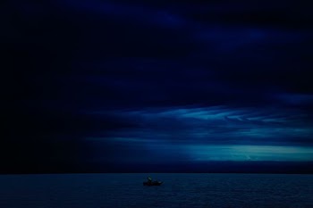person on boat under cloudy sky during nighttime