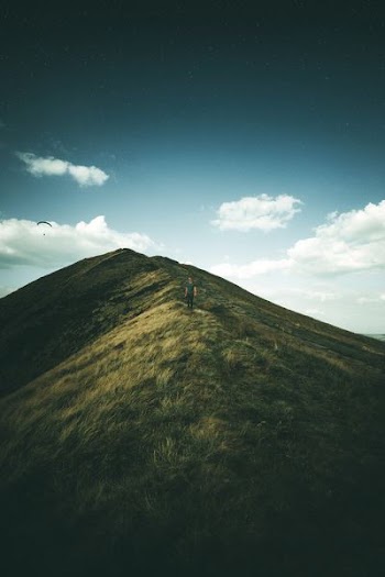 person on green grass mountain