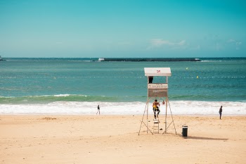Person on Ladder of Beach Shore Guardhouse