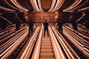person on mirrored escalator