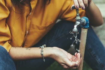 Person Opening Faucet And Washing Own Hands