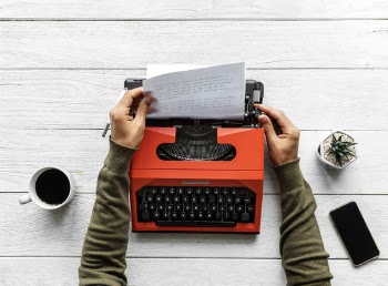 Person Operating Red Typewriter