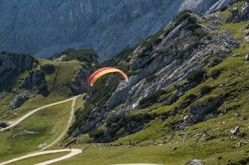 Person Parasailing Near the Mountain