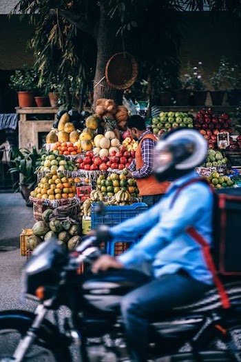 person picking fruits white person riding on motorcycle during daytime