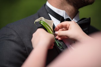 Person Pinning Flower On Suit Jacket