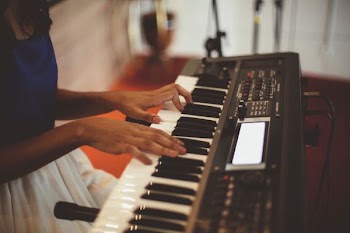 person playing a black electronic keyboard
