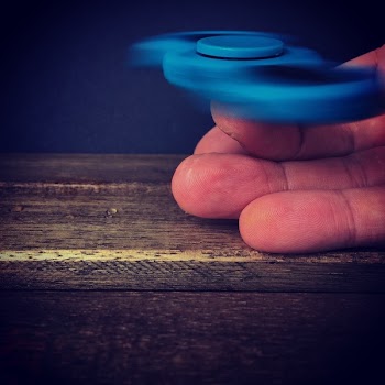 Person Playing Blue Hand Spinner