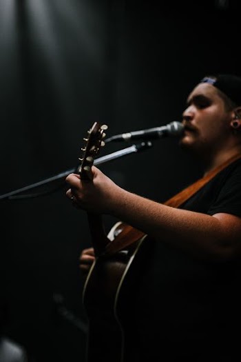person playing guitar while singing