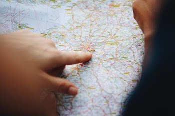 person pointing paris on map