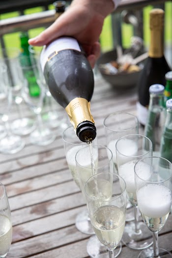 Person Pouring Champagne into Glasses