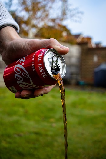 Person Pouring Coca Cola Can