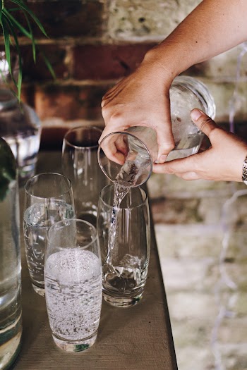 Person Pouring Liquid from Pitcher