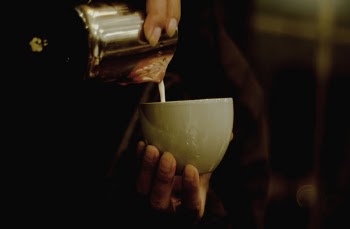 Person Pouring Liquid In Ceramic Cup