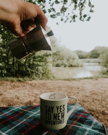 Person Pouring Liquid in Mug from Moka Pot