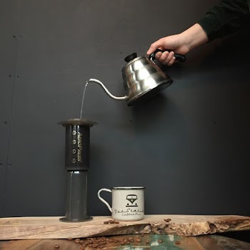 Person Pouring Liquid on Black and Brown Container