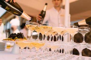 Person Pouring Liquor In Cocktail Glasses