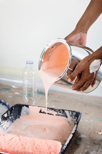 person pouring peach paint