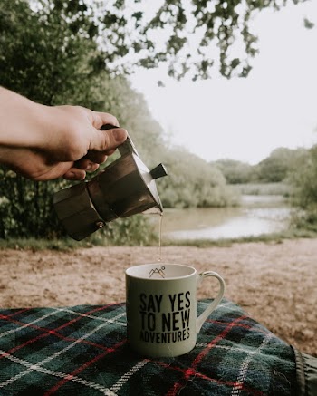Person Pouring Tea in Cup