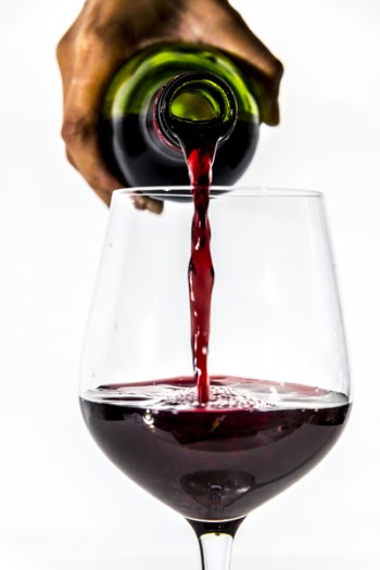 Person Pouring Wine into Wine Glass