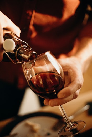 Person Pouring Wine on Wine Glass