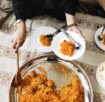 Person Putting Cooked Rice on Plate