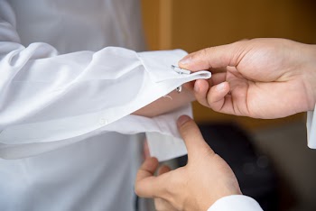 Person Putting Cufflinks on Dress Shirt