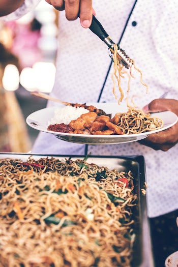 Person Putting Noodles Plate