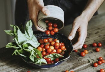 Person Putting Tomatoes on Bowl