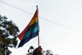 Person Raising a Multicolored Flag
