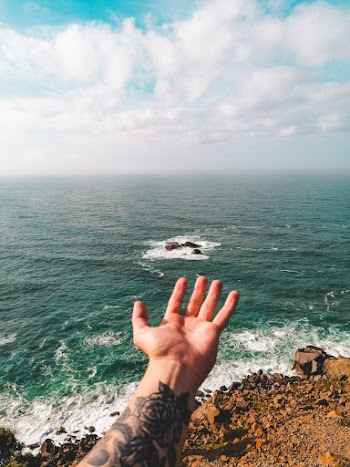 Person Reaching Out on Body of Water
