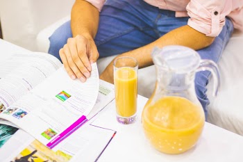 Person Reading With Juice Beside