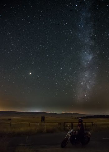 person rides on motorcycle under starry sky