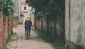 Person Riding Bicycle in the Middle of an Alley
