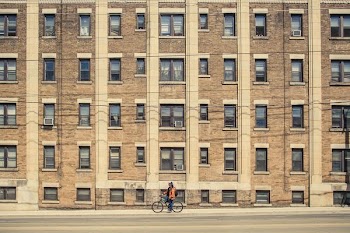 person riding bicycle near brown building