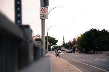 person riding bicycle on road near vehicles at daytime