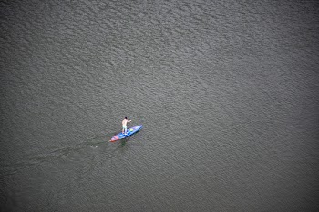 Person Riding Blue and Red Paddleboard on Water