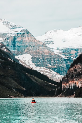 Person Riding Boat on Calm Body of Water