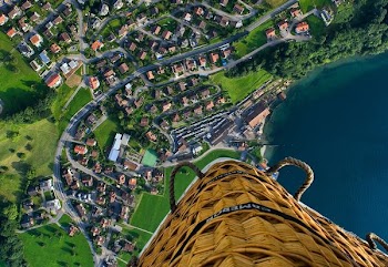 person riding hot air balloon taking photo of village near sea during daytime