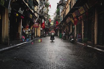 person riding motor scooter near building