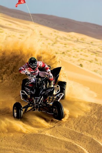 person riding on ATV and drift on sand