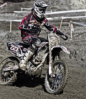 Person Riding on Motorcycle on Motocross Race Track Wearing White and Black Oakley Full Face Helmet during Daytime